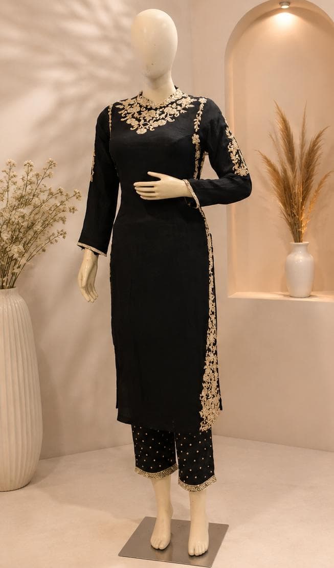 A black kurta and trousers with gold zari floral embroidery across the yoke and sleeves, with a matching gold-bordered black dupatta